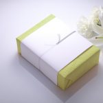 白いお花と掛け紙を掛けた緑色のボックス