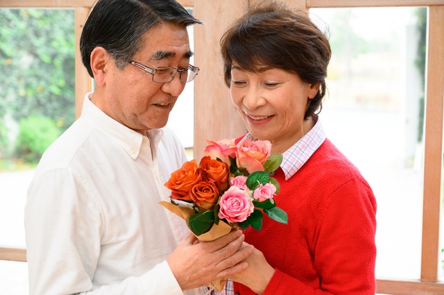 花束を持つ60代の夫婦　還暦祝い
