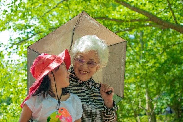 日傘とさして孫と歩く女性