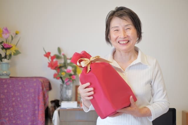 赤い袋に入ったプレゼントを持つ女性
