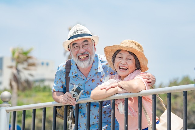 帽子をかぶって笑顔の老夫婦