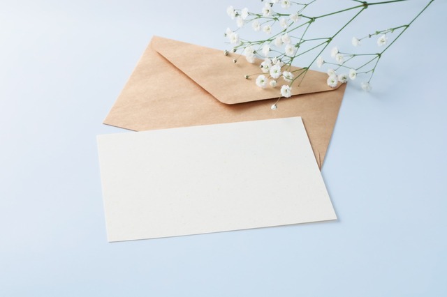 封筒と白い紙と、小さな白い花