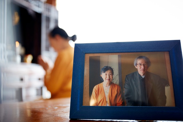 お中元の時期が過ぎた場合の対応解説。仏壇を拝む人と家族写真。