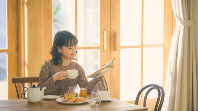 紅茶を飲みながら読者をする女性