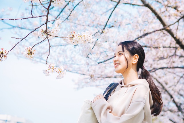 桜の下でほほ笑む女性