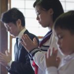 子供二人と父親が故人の冥福を祈る法事
