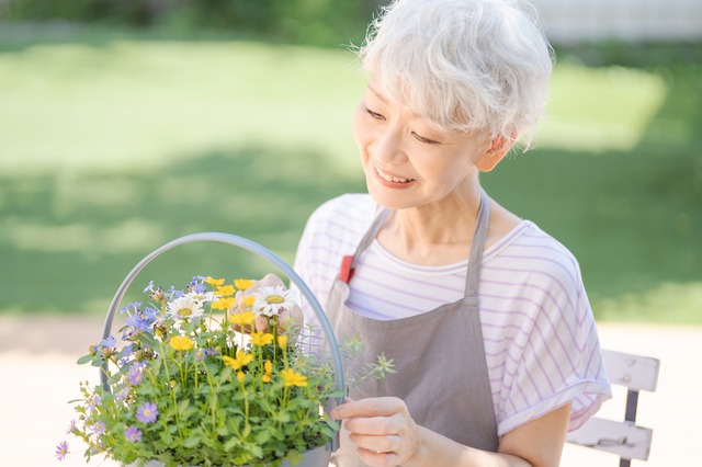 女性が庭で花を手入れしている　敬老の日　おばあちゃん