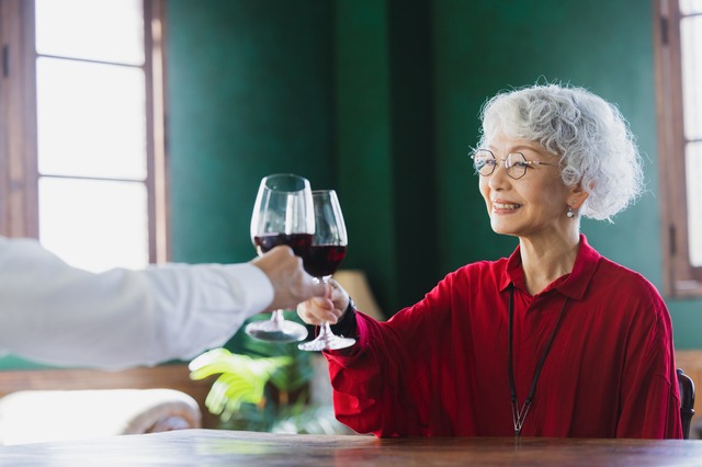 初任給・初ボーナスに贈られた赤ワインで乾杯する60代～70代の女性