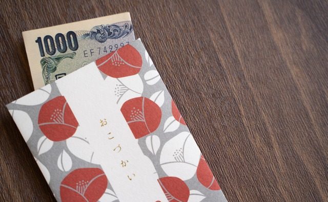 「おこづかい」と書かれたポチ袋と千円札