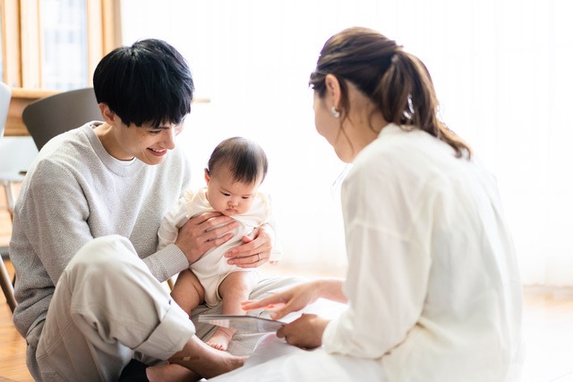 絵本を読む赤ちゃんと家族