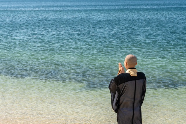海に向かって読経する僧侶